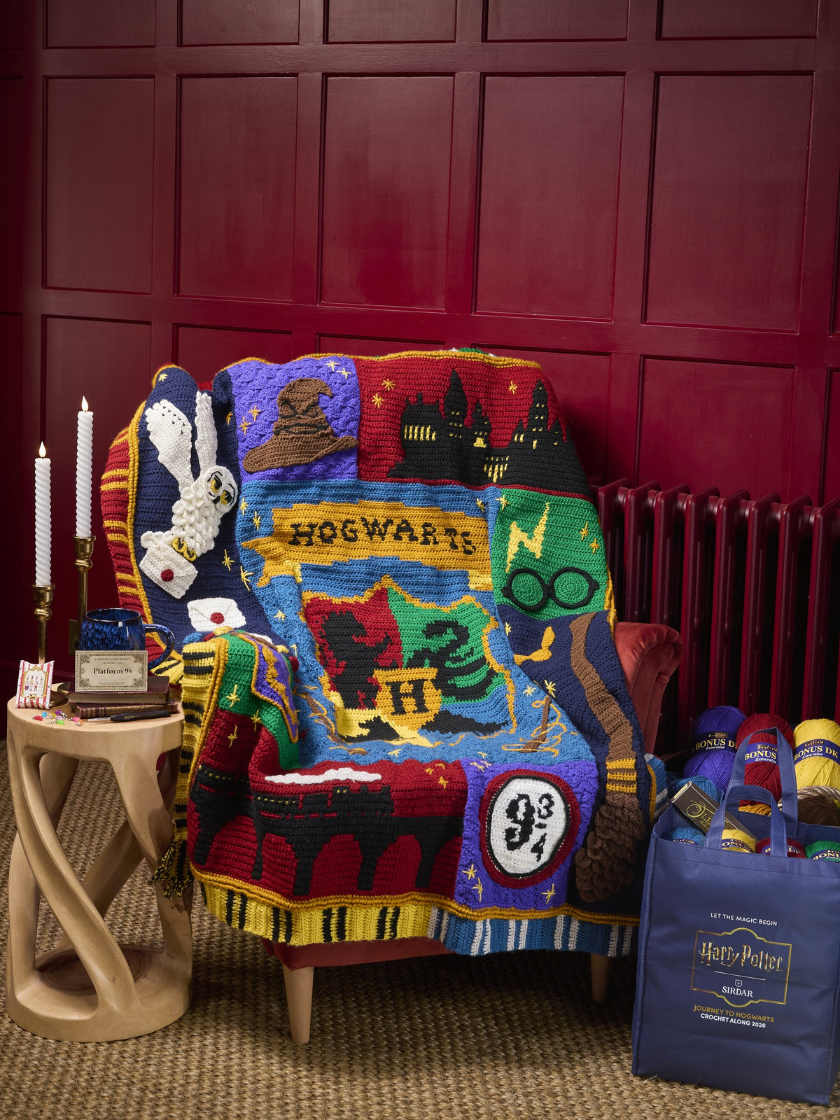The Harry Potter Crochet Along blanket on an armchair beside the Harry Potter tote bag